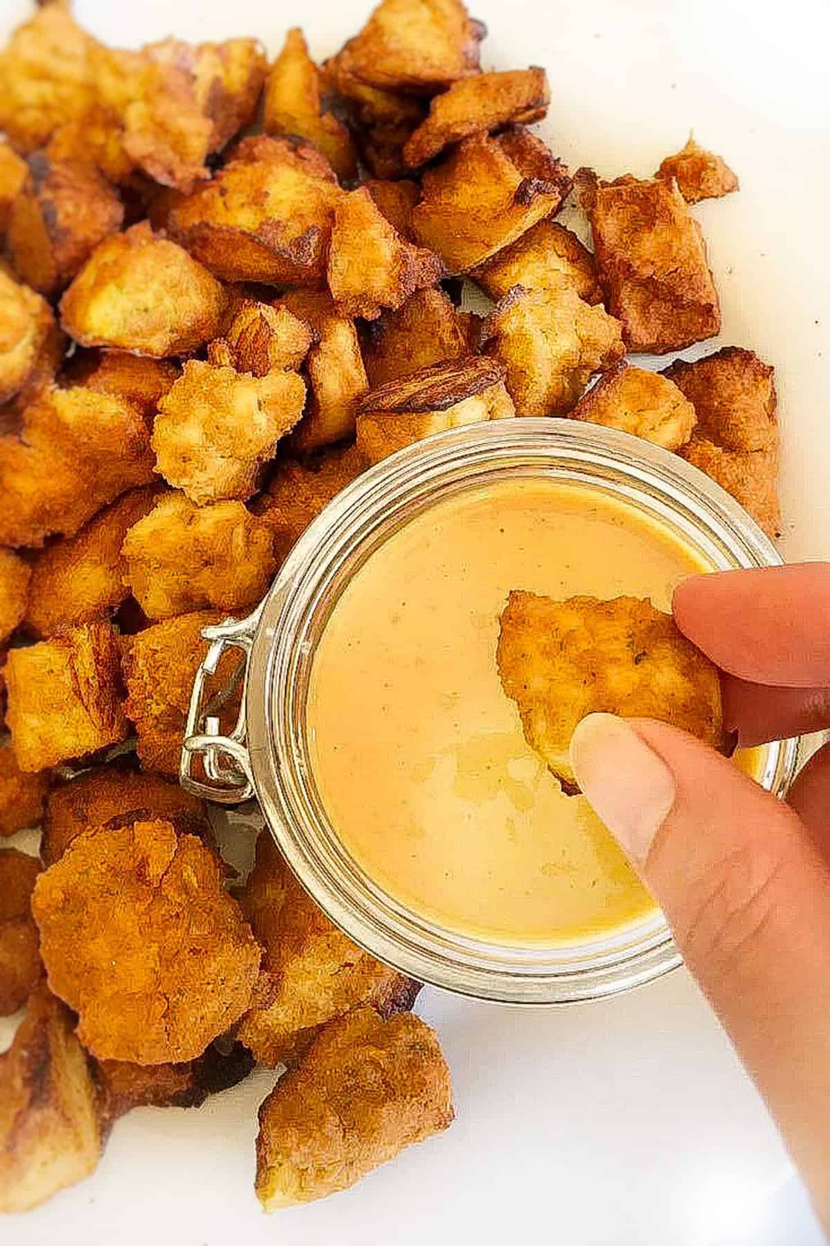 Vegan honey mustard being dipped into sauce.