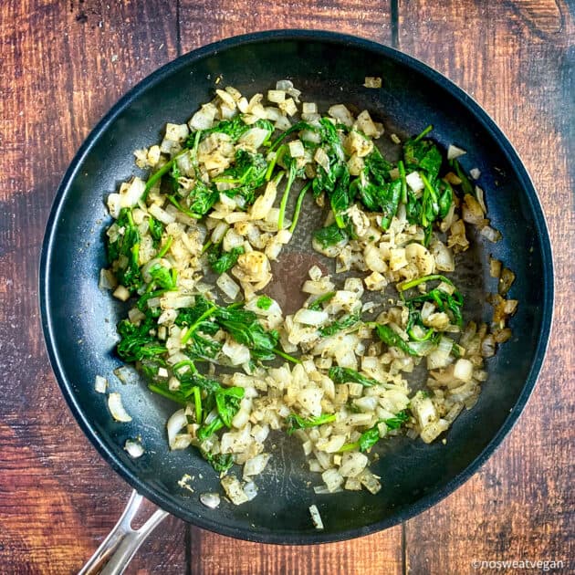 Spinach and onion mixture in skillet.