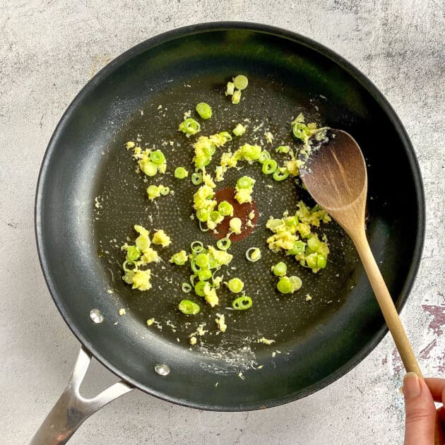 Green onion, garlic, and ginger cooking in skillet.