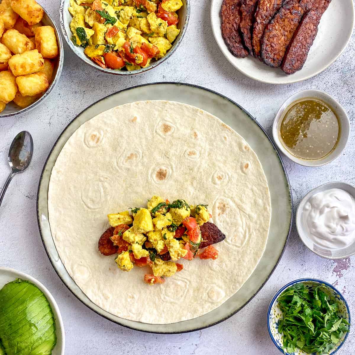 Tempeh bacon and tofu scramble on tortilla.