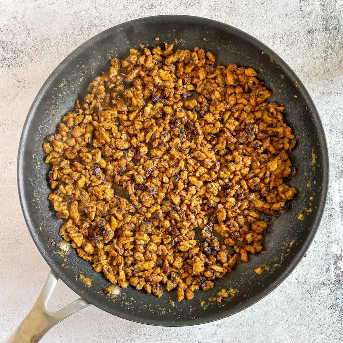 Vegetarian carne asada cooked in skillet.