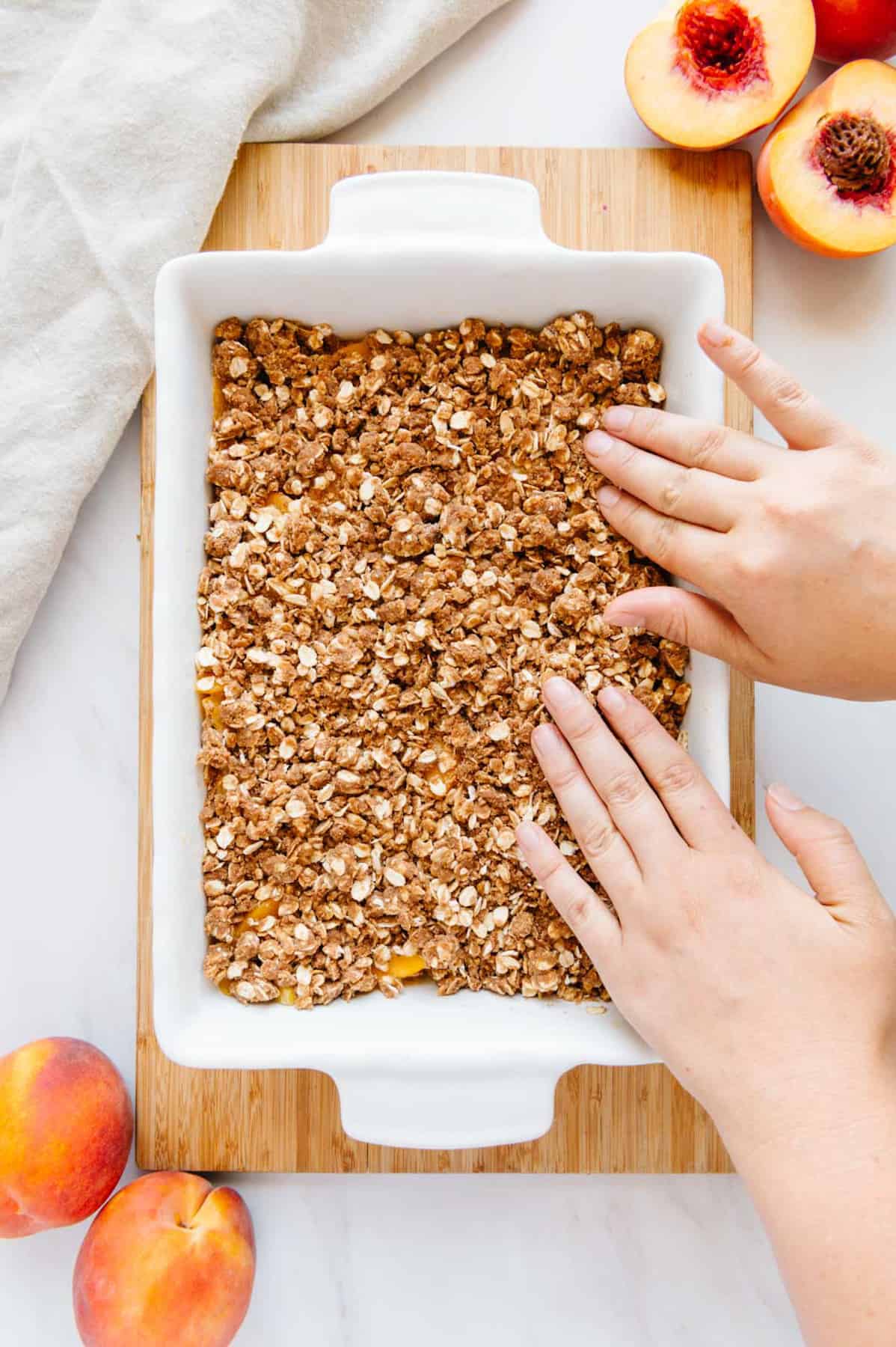 Hands pressing down crisp topping.
