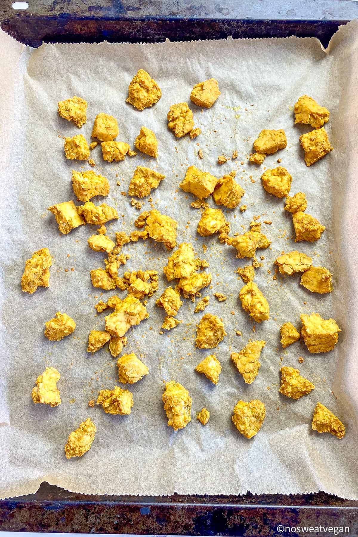 Baked curried tofu on a baking sheet.
