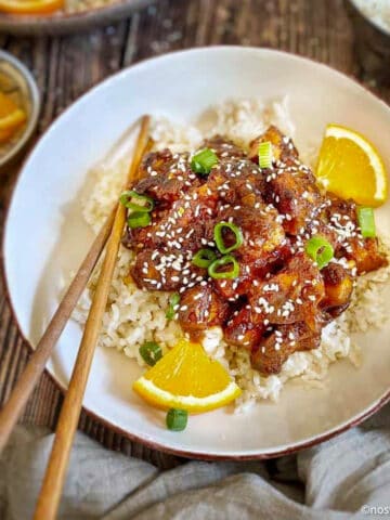 Orange tofu in a bowl with rice.