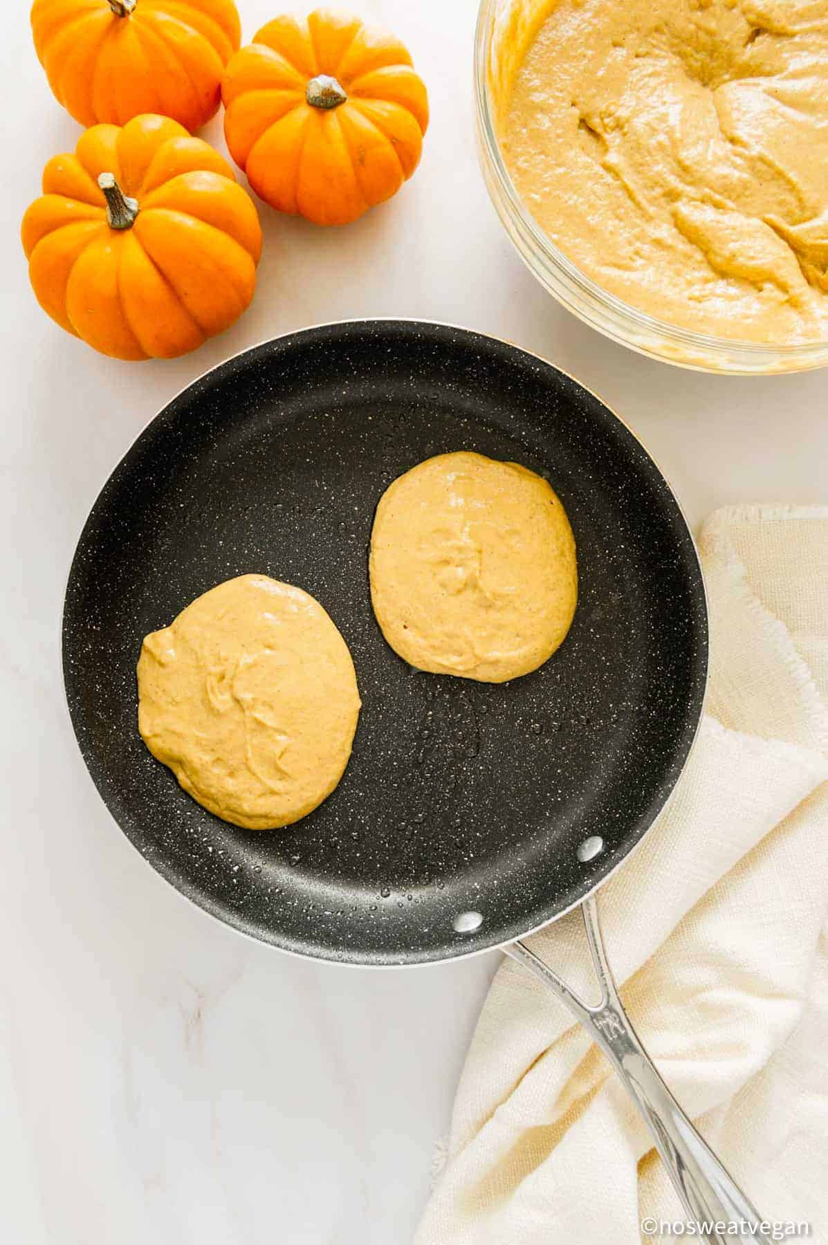 Vegan pumpkin pancakes in a skillet.