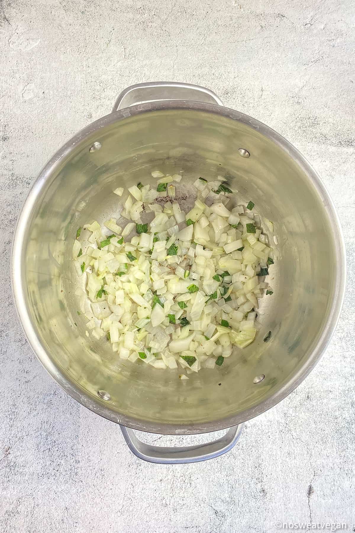Onions and sage cooked in a soup pot.