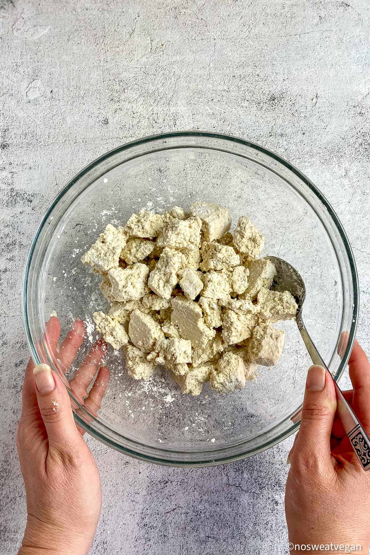 Bowl with tofu chunks mixed with cornstarch.