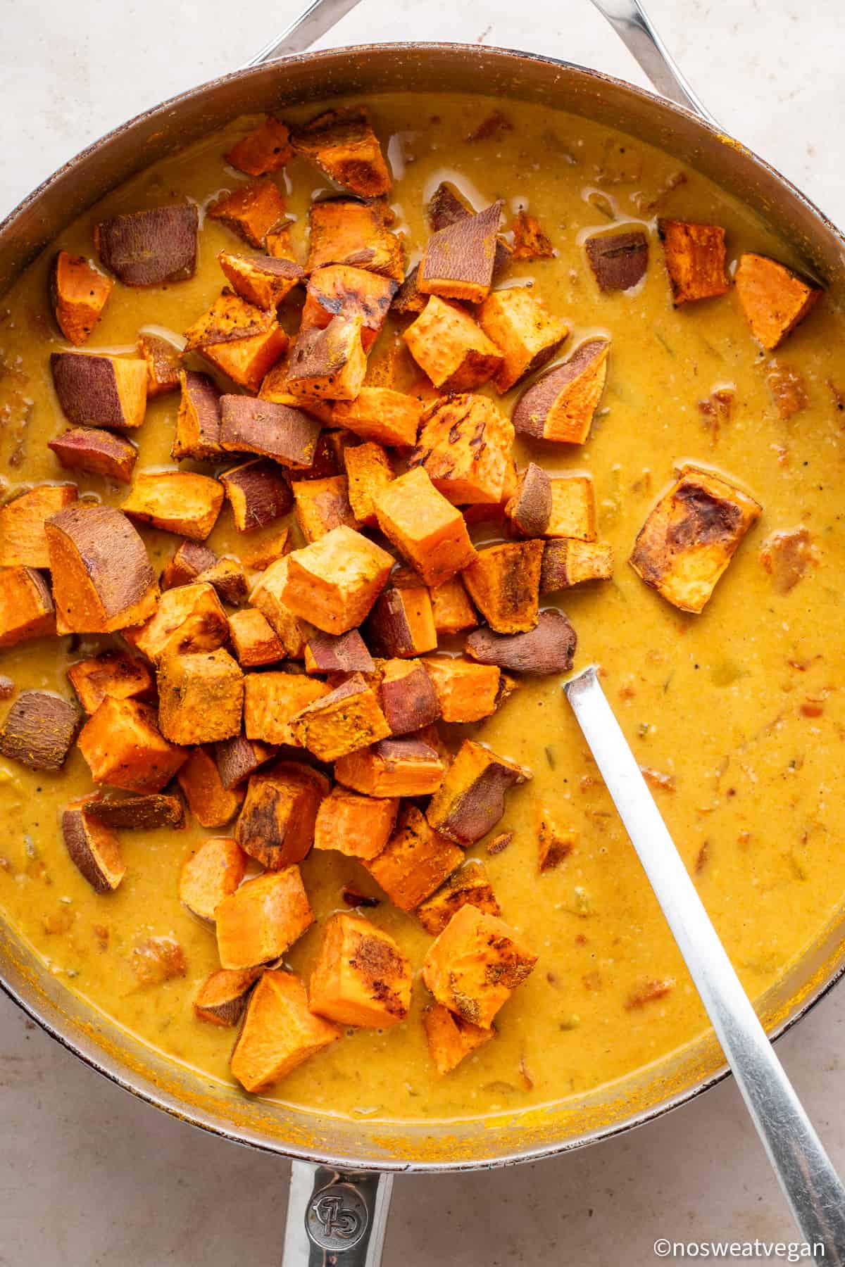 Sweet potato cubes added to curry.