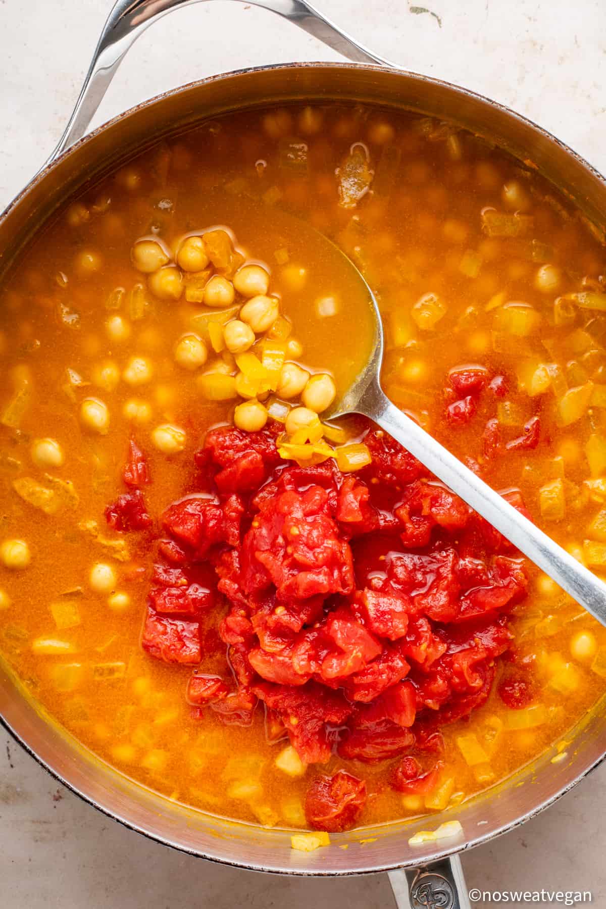 Canned tomatoes added to curry.