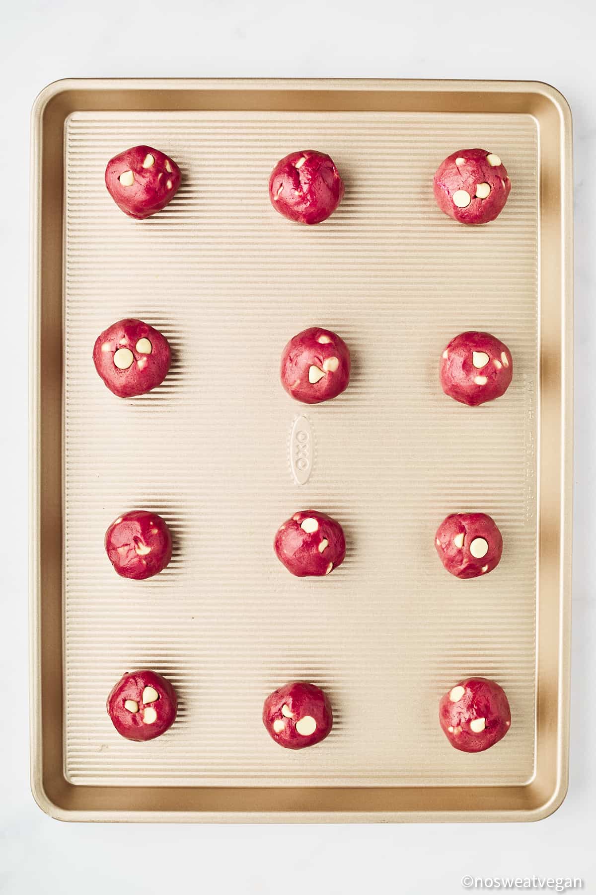Vegan red velvet cookies uncooked on a baking sheet.
