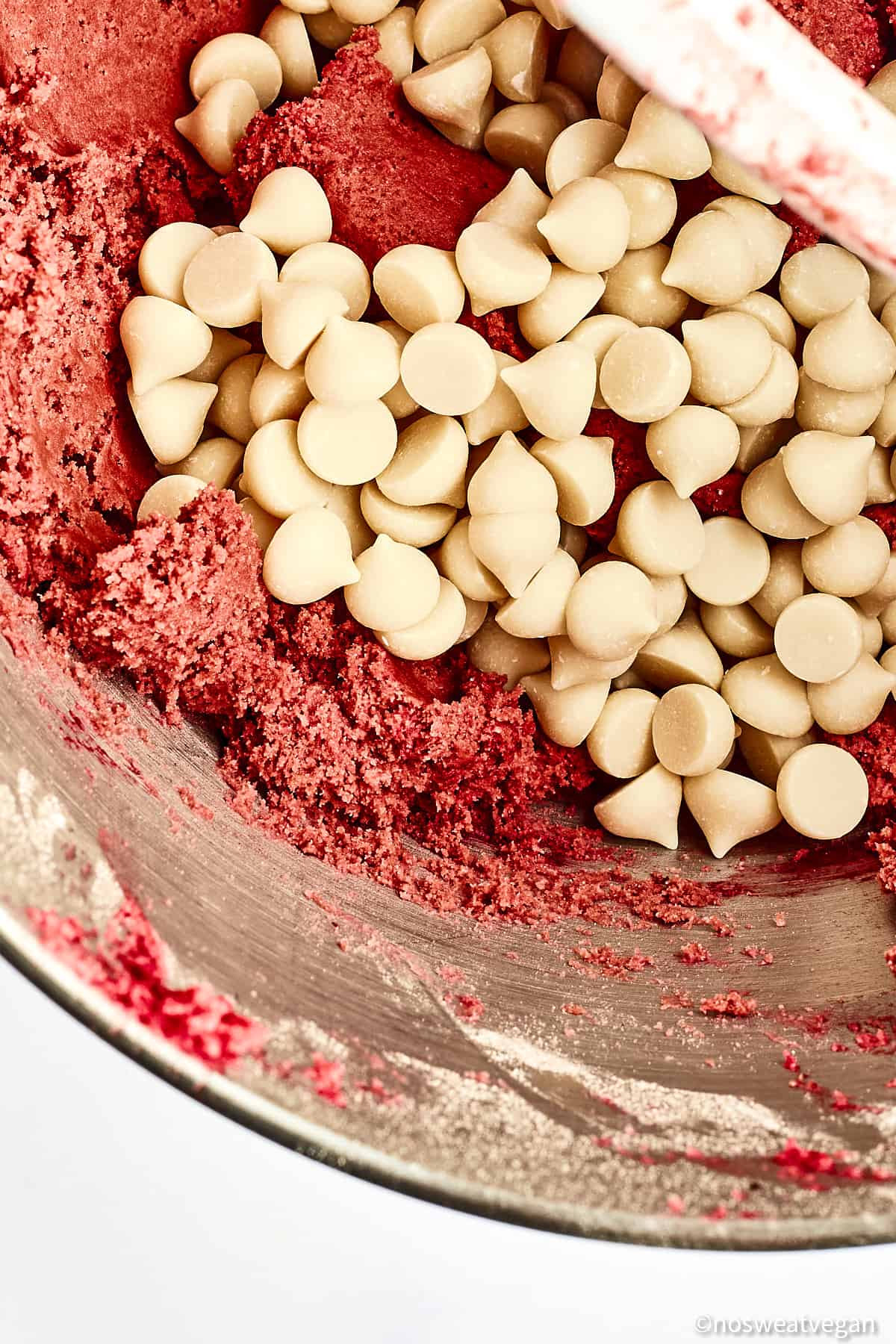 Vegan white chocolate chips added to red velvet cookie dough.