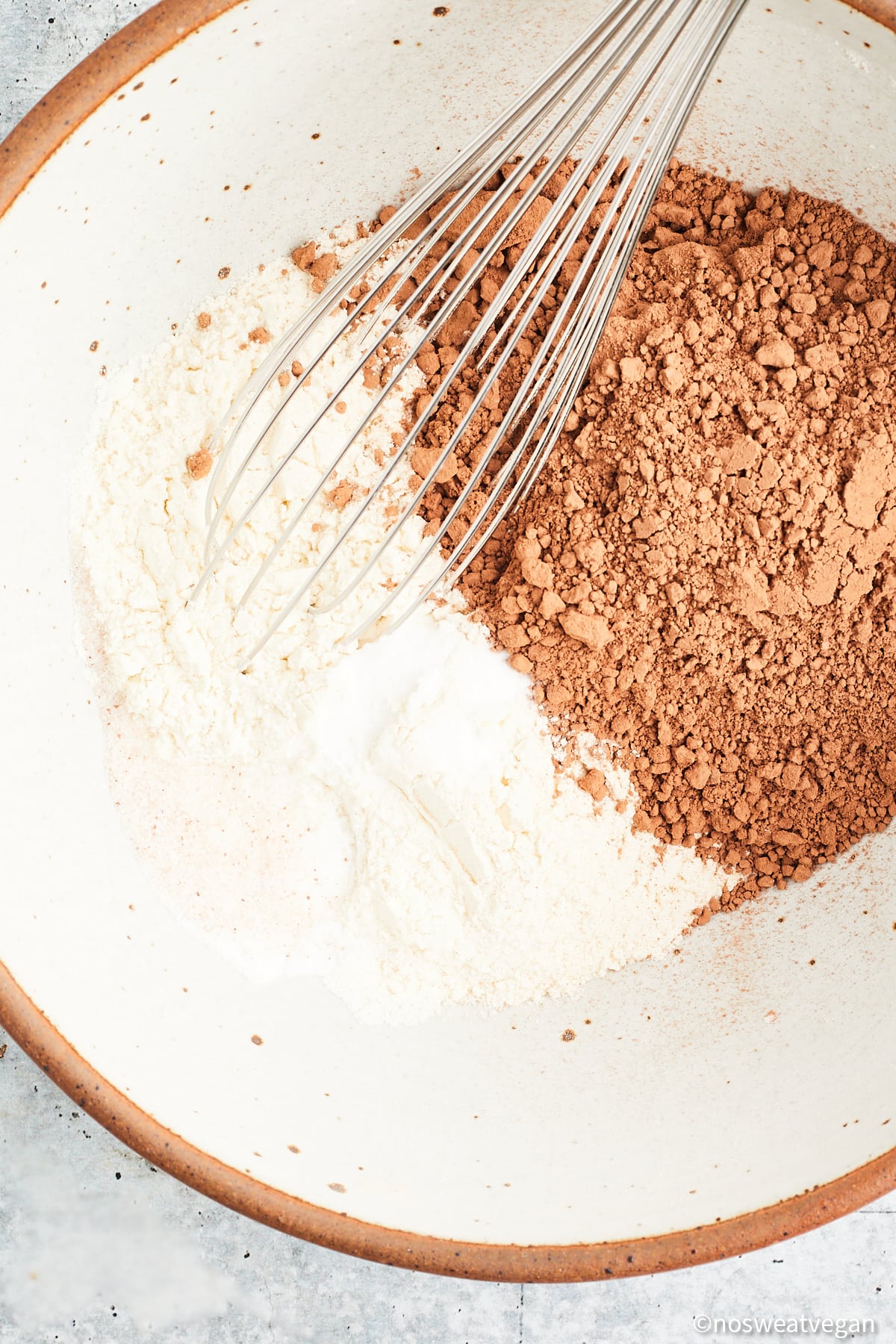 Whisking flour and cocoa powder.