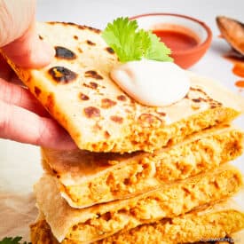 Hand picking up buffalo chickpea quesadilla.
