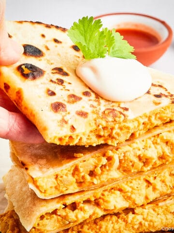Hand picking up buffalo chickpea quesadilla.