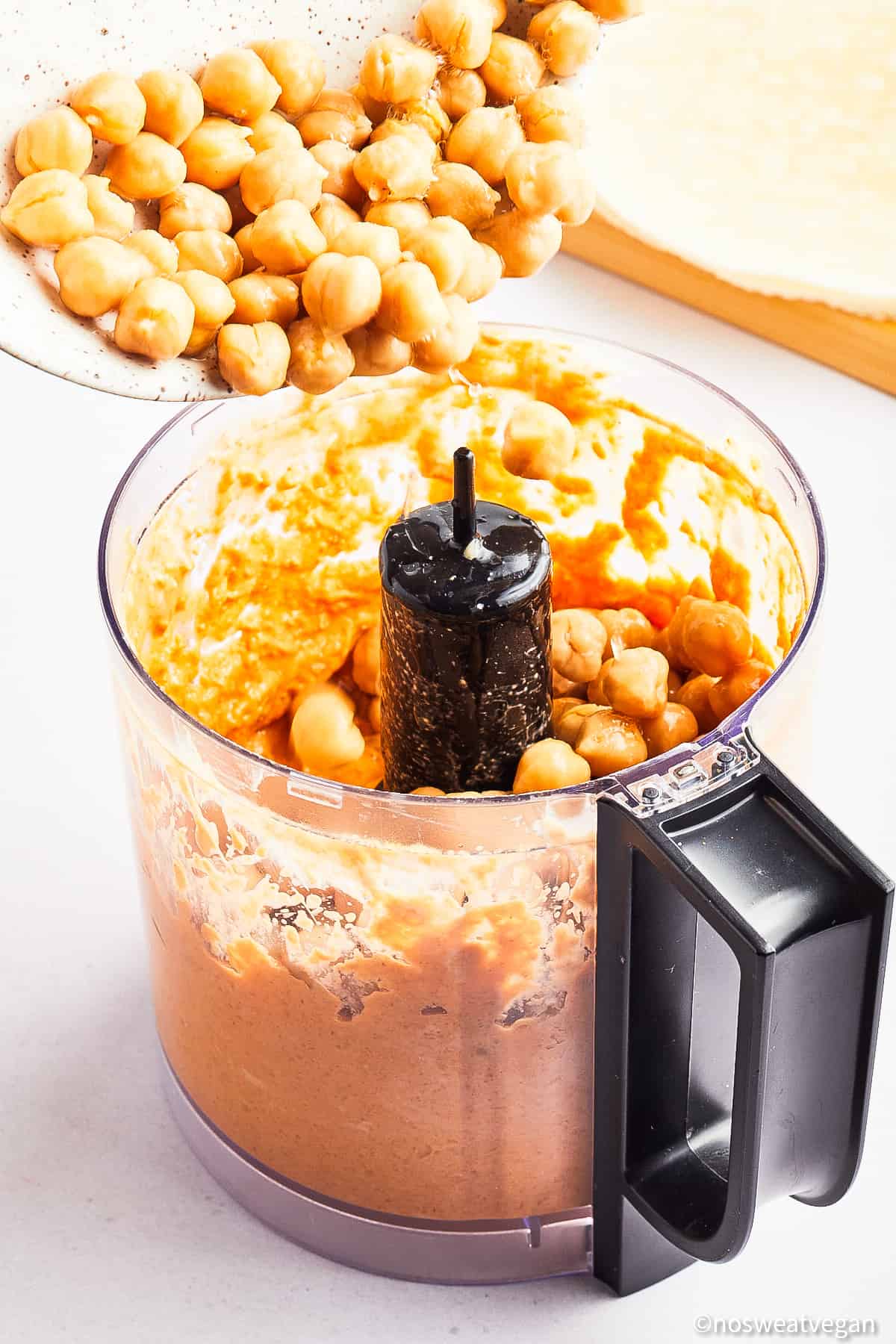 Adding chickpeas to the food processor.