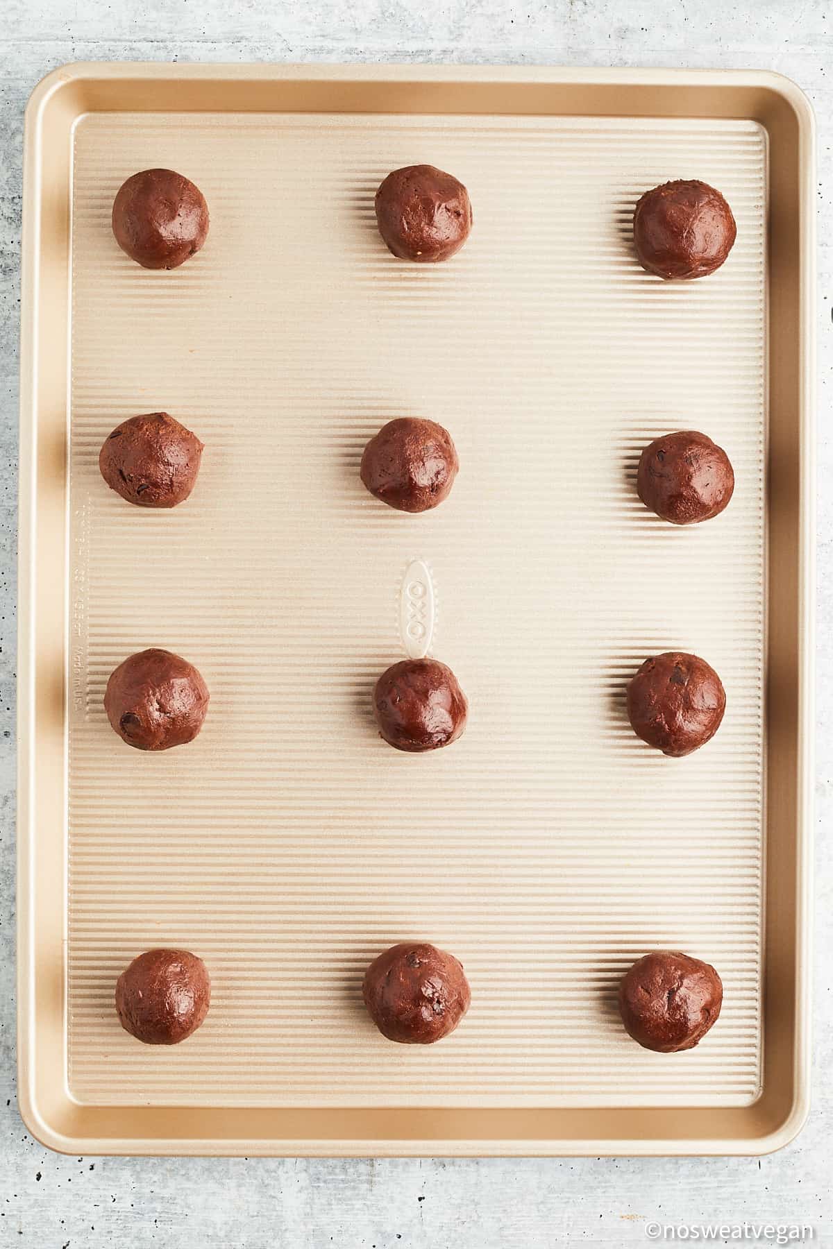 Unbaked vegan double chocolate chip cookies on a baking sheet.