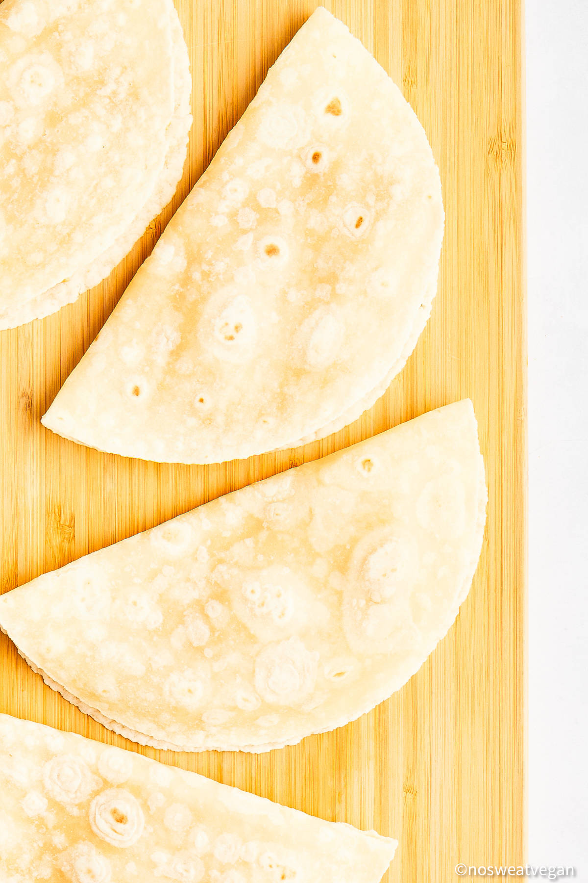 Filled tortillas on a cutting board.