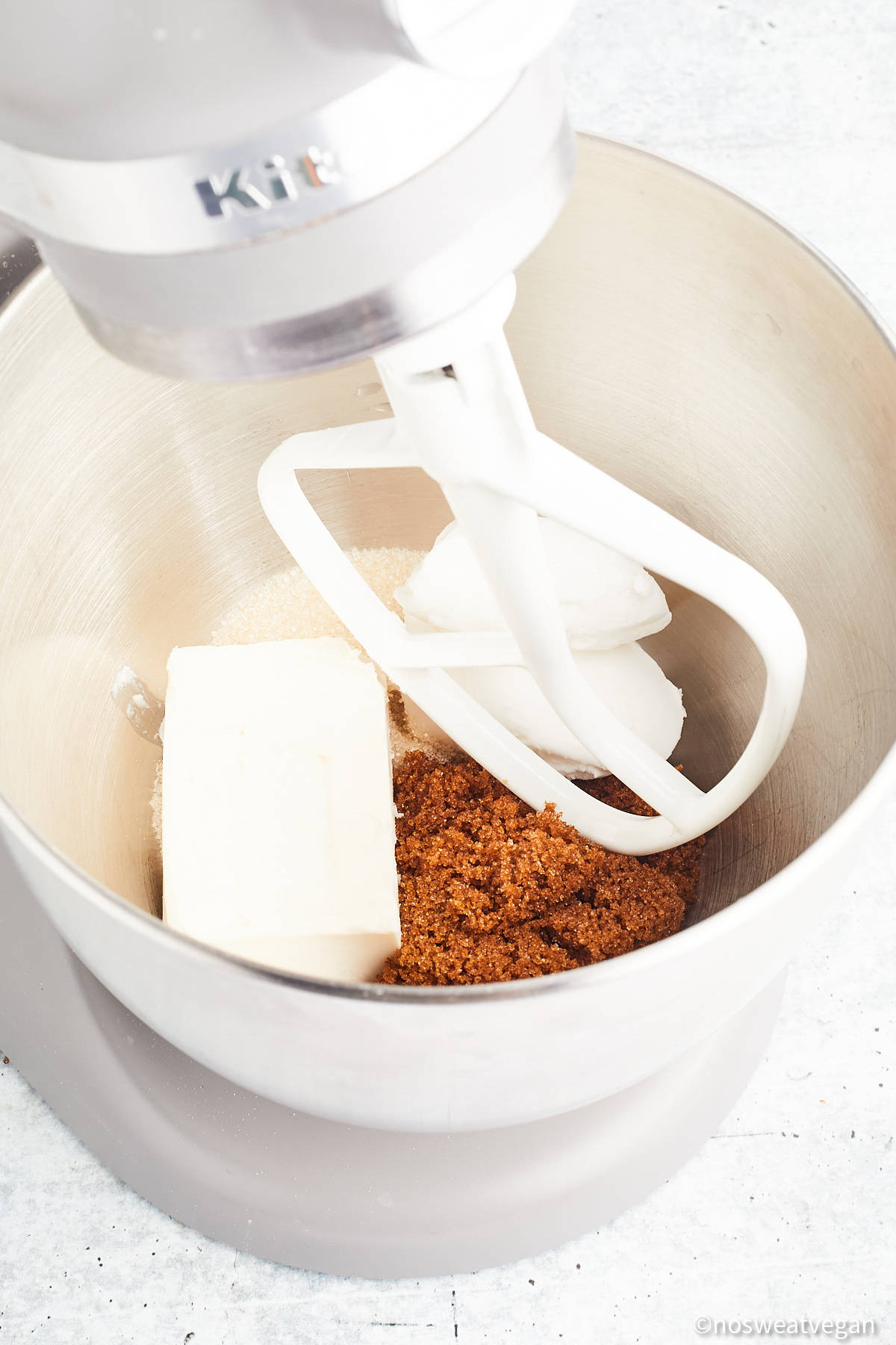 Vegan butter, cream cheese, and brown sugar in a mixer.