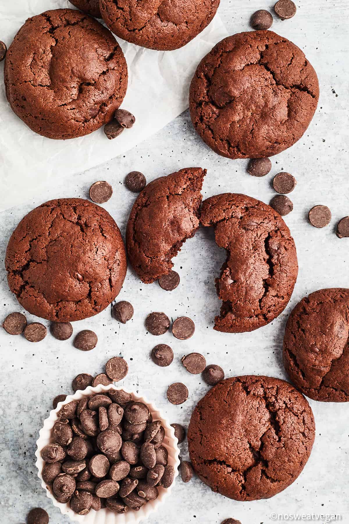 Vegan chocolate chocolate chip cookies on a white surface.