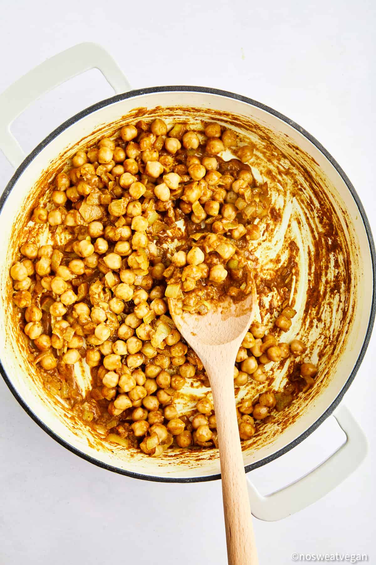 Adding chickpeas to curry.