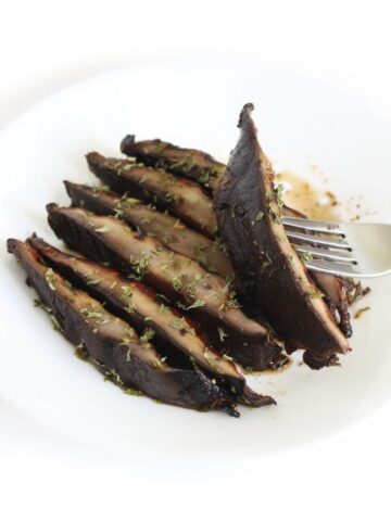 Grilled Portobello mushrooms cut on a plate.