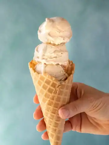 Vegan oat milk vanilla ice cream in a cone.