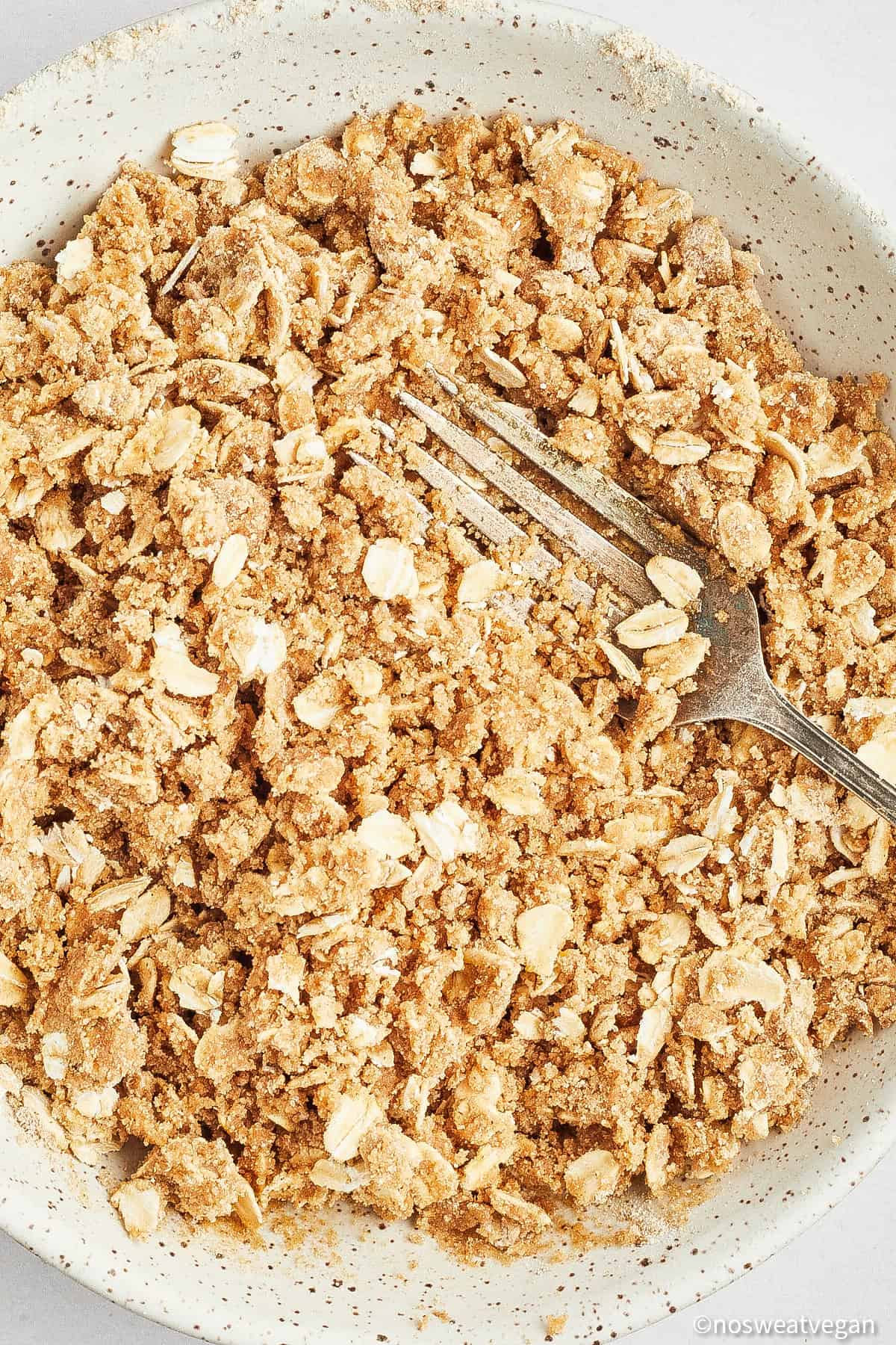 Crumble topping in a bowl with a fork.