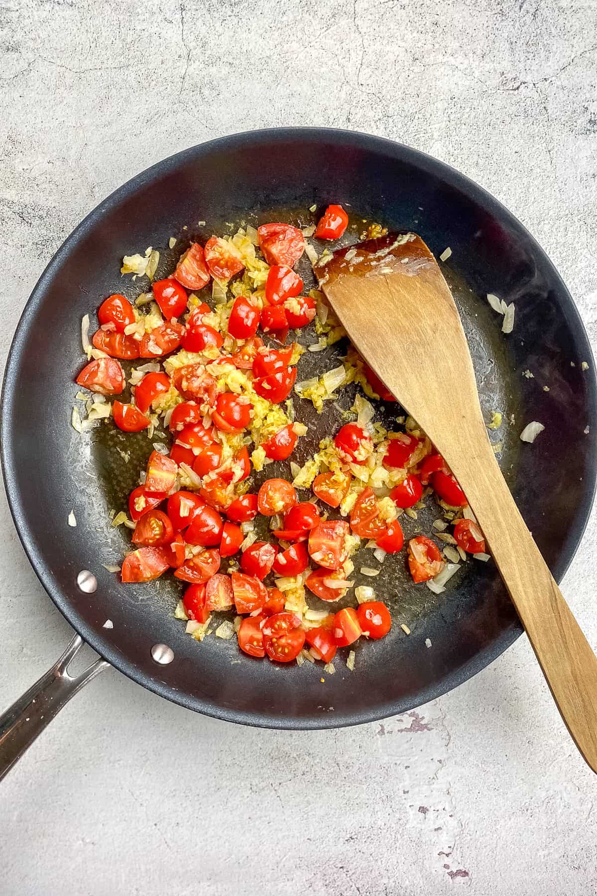 Tomatoes and seasoning added to the skillet.