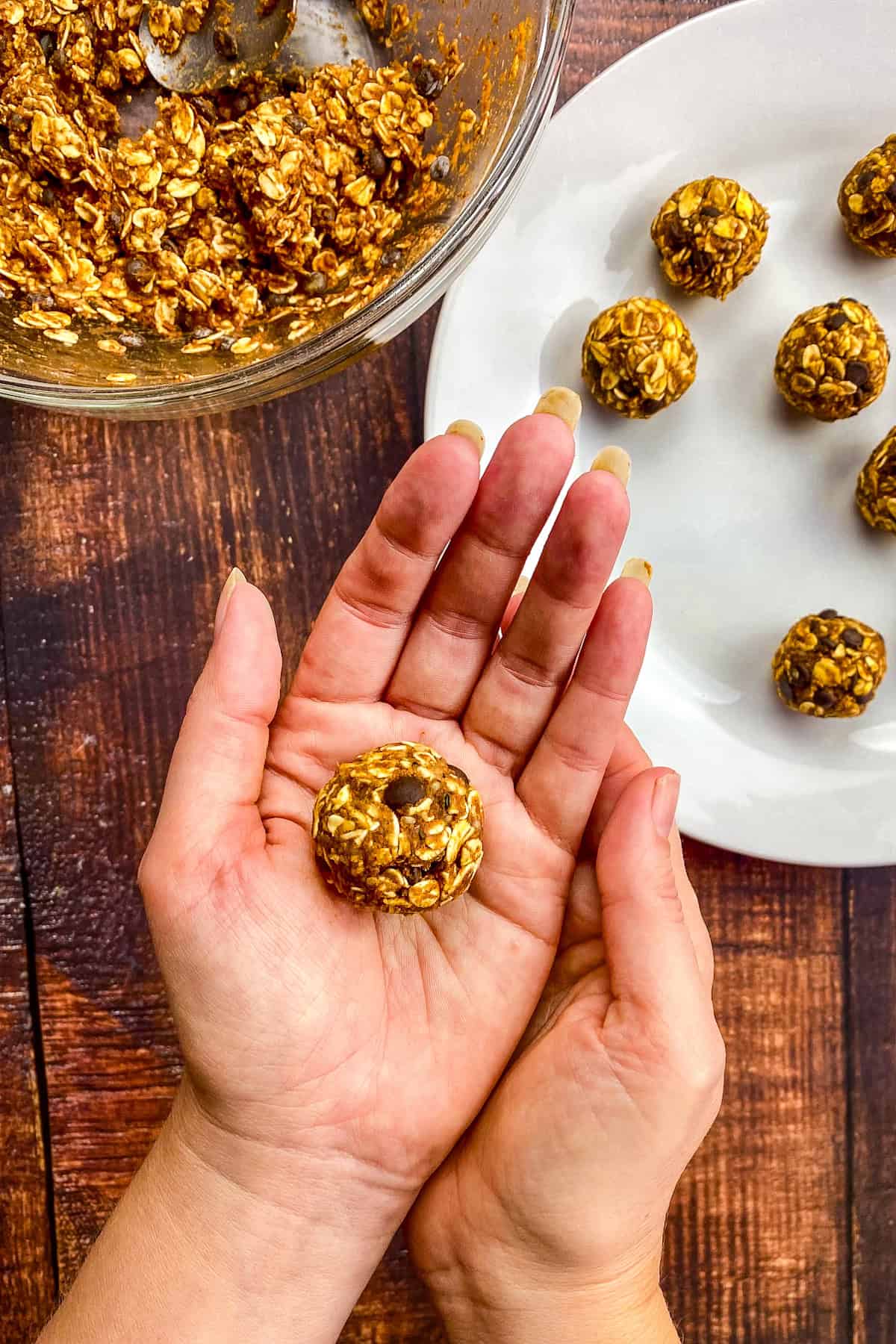Hand holding a no-bake pumpkin ball.
