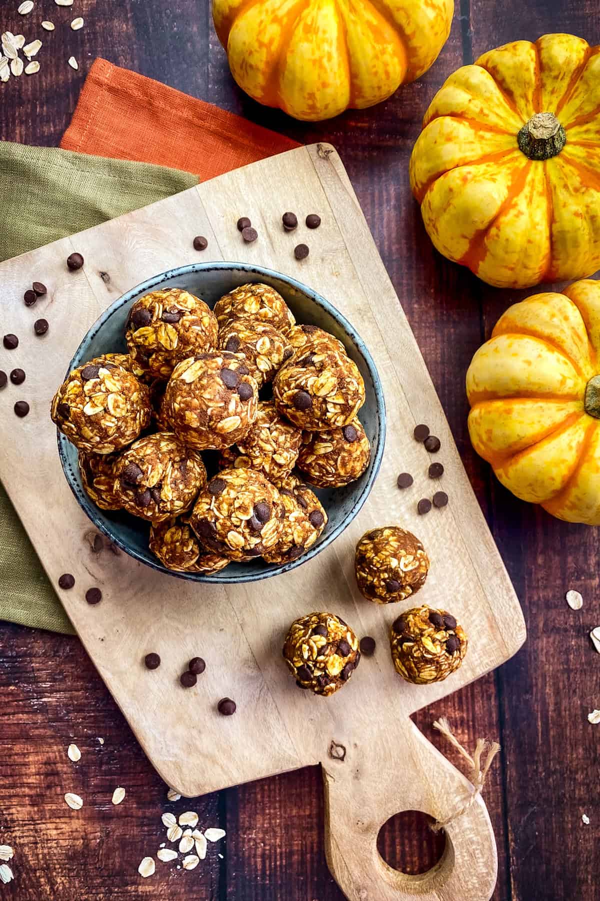 No bake pumpkin balls in a bowl on a cutting board.