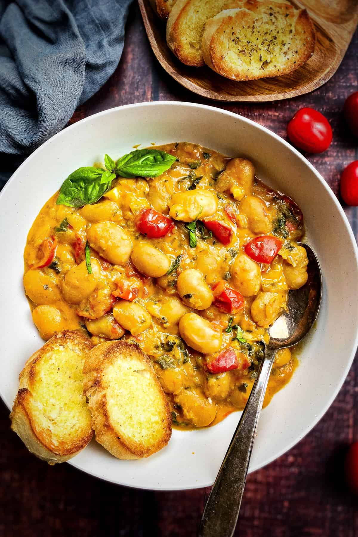 Closeup of a bowl of vegan butter beans with bread.