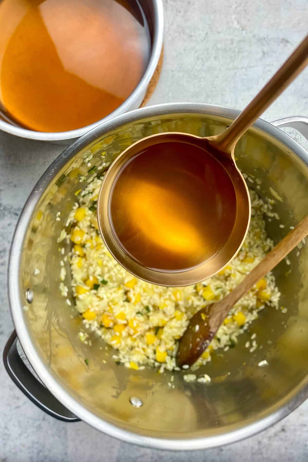 Ladle adding veggie broth to risotto.