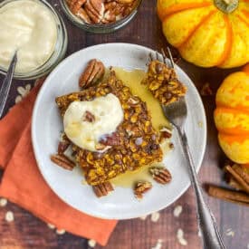 Vegan pumpkin baked oatmeal on a plate with toppings.
