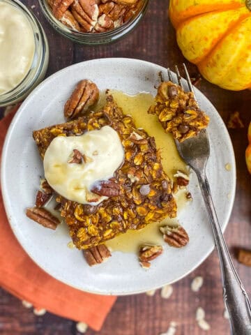 Vegan pumpkin baked oatmeal on a plate with toppings.