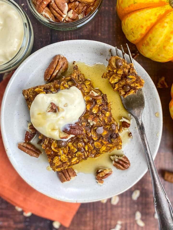 Vegan pumpkin baked oatmeal on a plate with toppings.